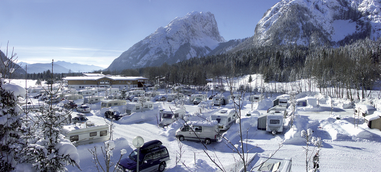 Verschneiter Campingplatz vor Bergpanorama