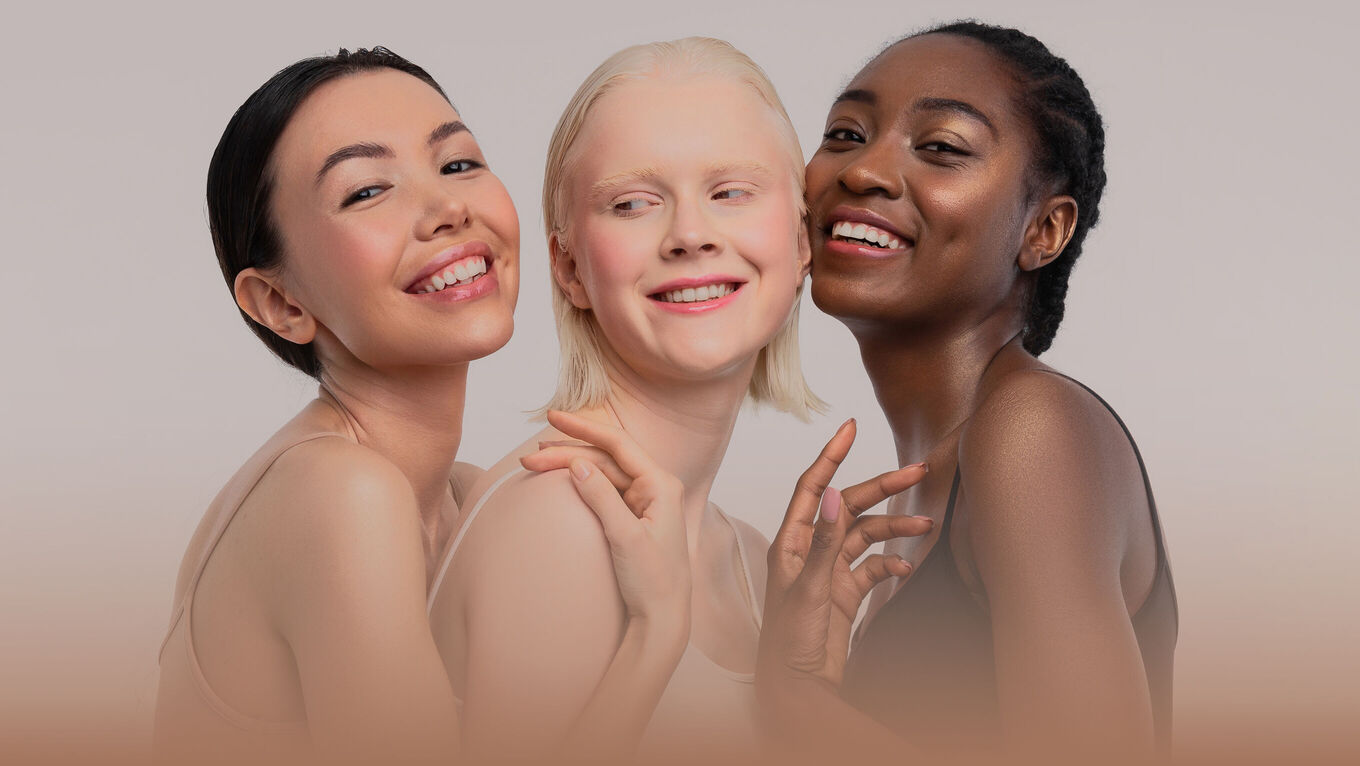 Drei lächelnde Frauen mit verschiedenen Hauttönen