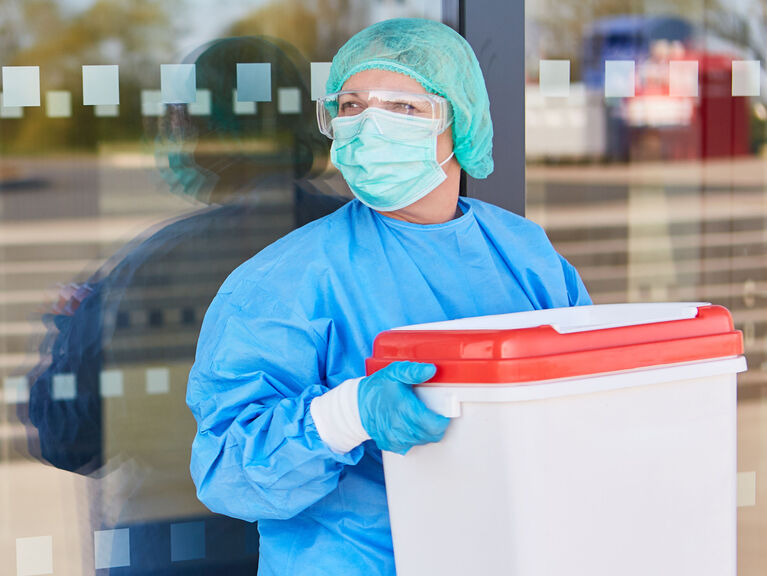 Arzt in OP-Kleidung mit Organspendebehälter Arzt in OP-Kleidung mit Organspendebehälter